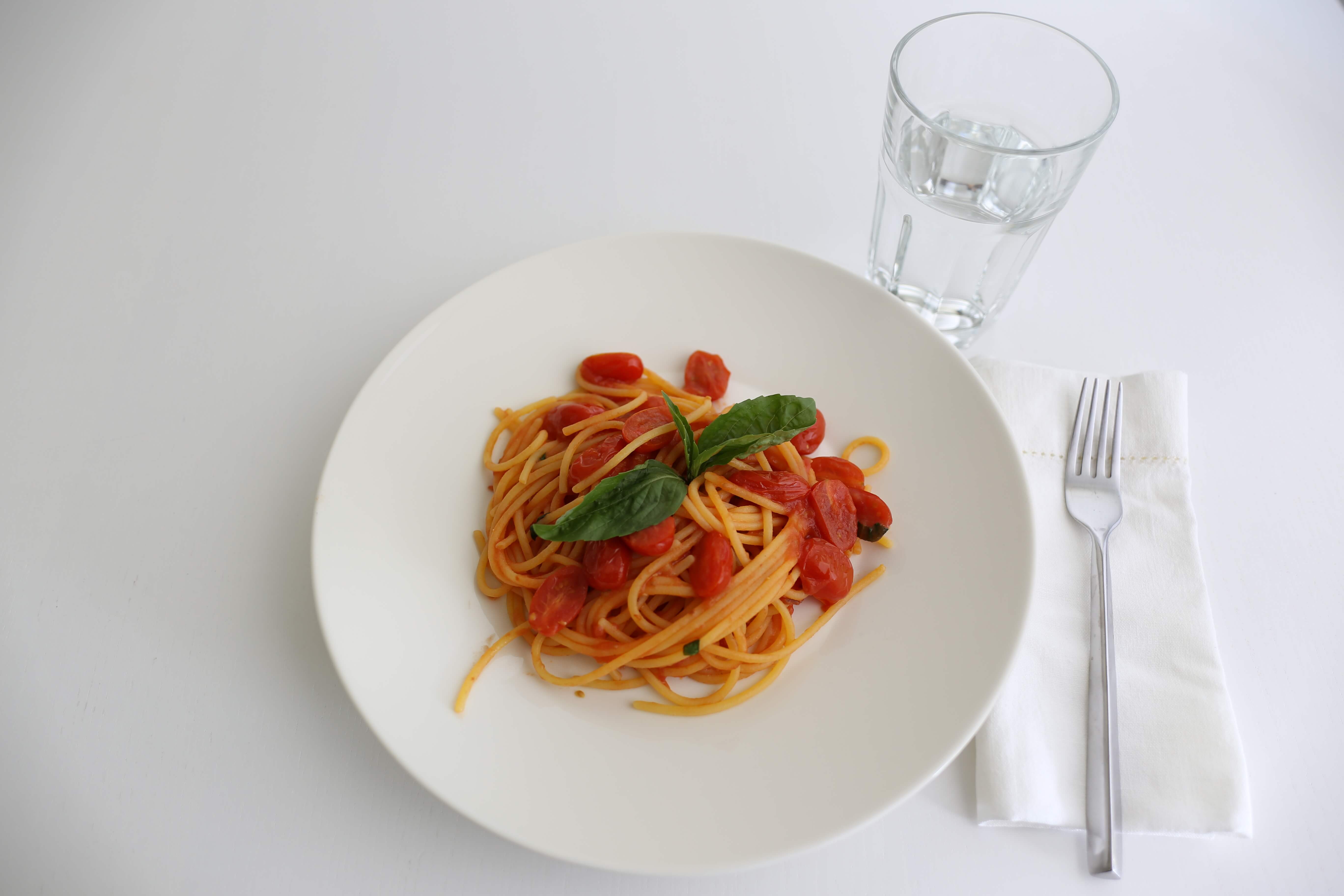 Gluten-free spaghetti with tomatoes and fresh basil.